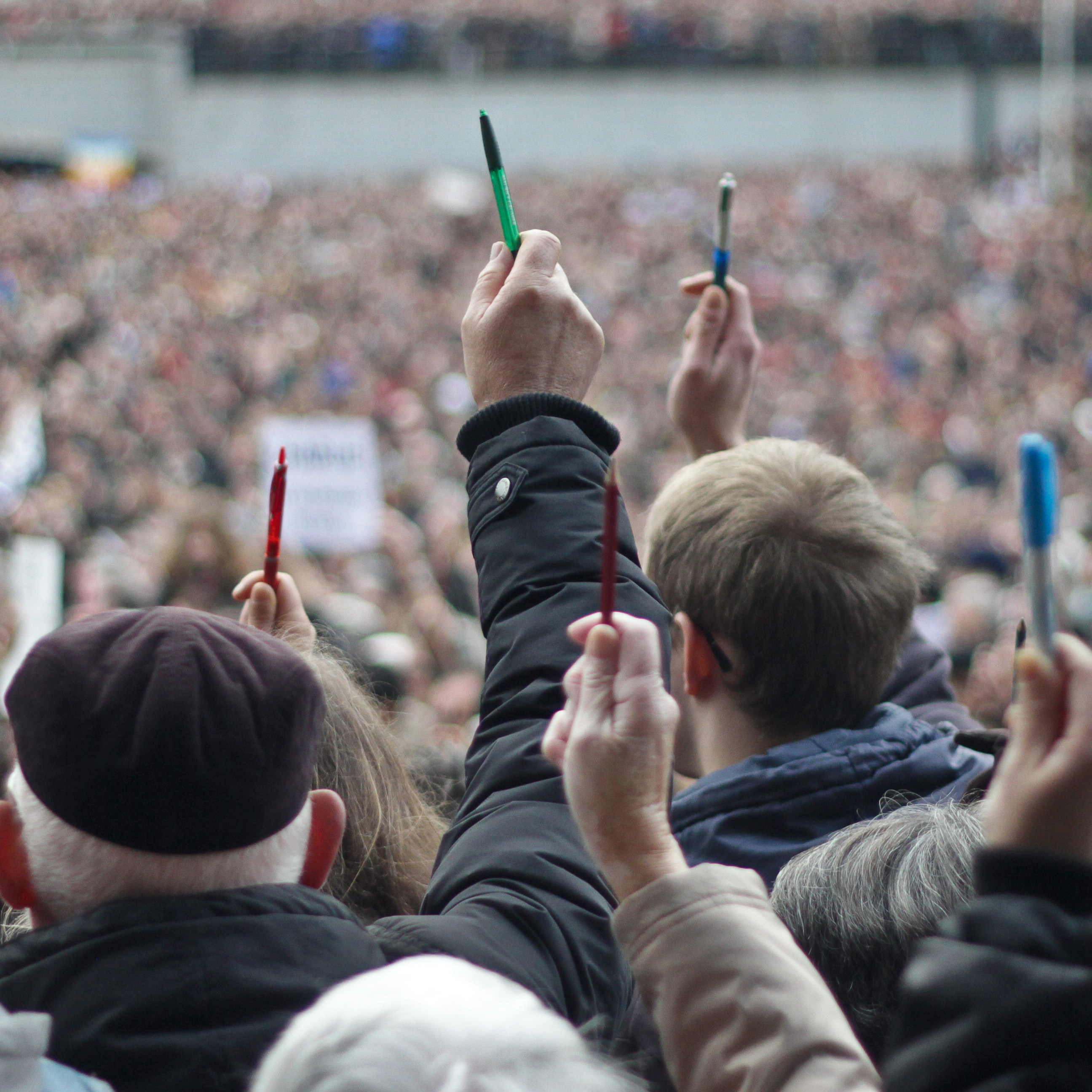 Crowd of protestors holding up pens and pencils