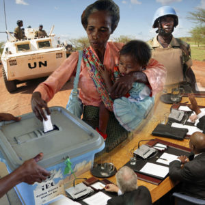 Collage of a women voting while holding a child, UN representatives voting, and UN peacekeepers