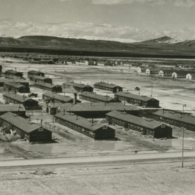 Several rows of long, one-story buildings on a flat desert plain.