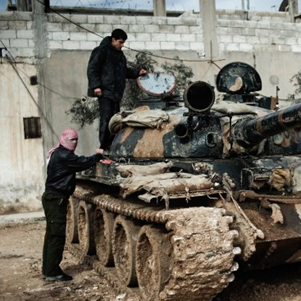 Two men with a camouflaged tank