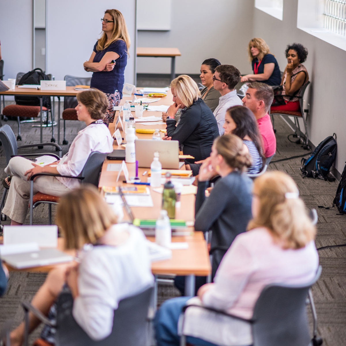 People sitting at a long table watching a presentation